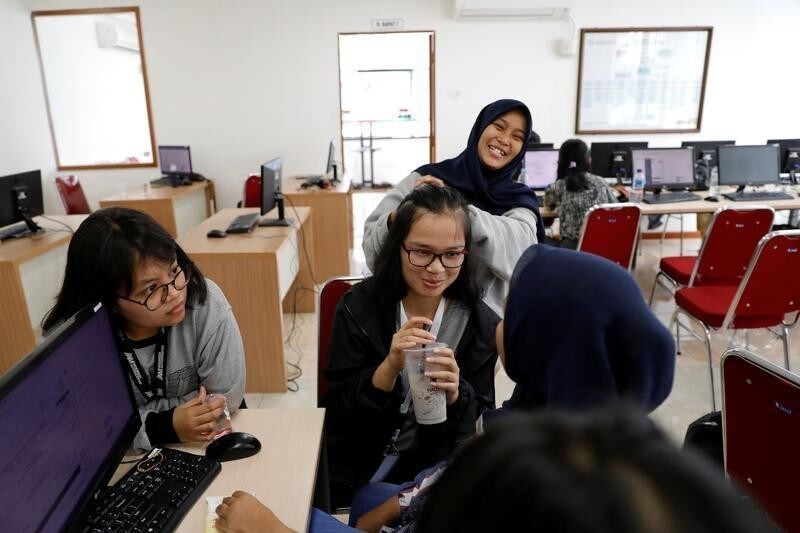 Volunteers share jokes during a break as they upload the details of vote tally forms, of this month's election, in a room at Joko Widodo's national campaign team office in Jakarta, Indonesia, April 29, 2019. Picture taken April 29, 2019. REUTERS/Willy Kurniawan - RC176BDA7F00