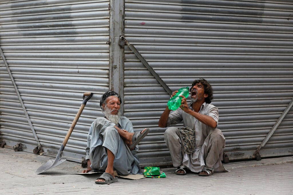 Daily wage laborers, wait for work as they sit outside closed shops, during lockdown amid the outbreak of coronavirus disease (COVID-19), at a market in Karachi, Pakistan April 14, 2020. REUTERS/Akhtar Soomro - RC2C4G9PM4NR