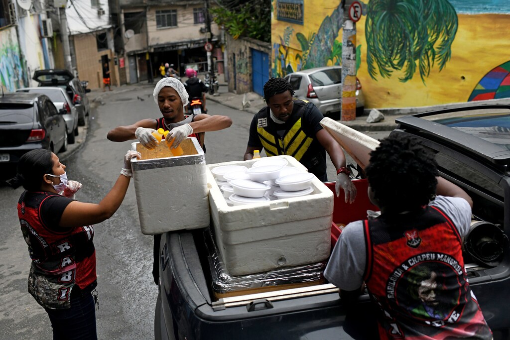 Un grupo de residentes del barrio marginal de Chapeu Mangueira, llevan cajas de comida para dársela a las personas sin hogar del barrio de Copacabana durante el brote de la enfermedad coronavirus (COVID-19), en Río de Janeiro, Brasil, el 11 de abril de 2020.