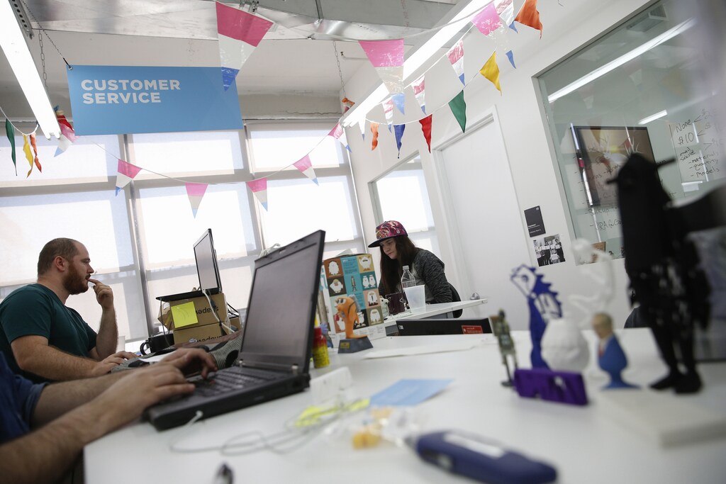 People work at the customer service area inside the Shapeways 3D printing office in the borough of Queens in New York, September 17, 2014. Shapeways is a young Dutch 3D printing firm that has two factories, one in Eindhoven in the Netherlands and one in New York, that let anyone - from haute-couture designers to cat-lovers - print what they want. CEO Peter Weijmarshausen moved the firm's headquarters to New York in 2010 to be close to tis main market and attract talent and investment. To match Insight EUROPE-STARTUPS/MAKERS Picture taken September 17, 2014. REUTERS/Shannon Stapleton (UNITED STATES - Tags: BUSINESS SCIENCE TECHNOLOGY) - RTR46Y1I