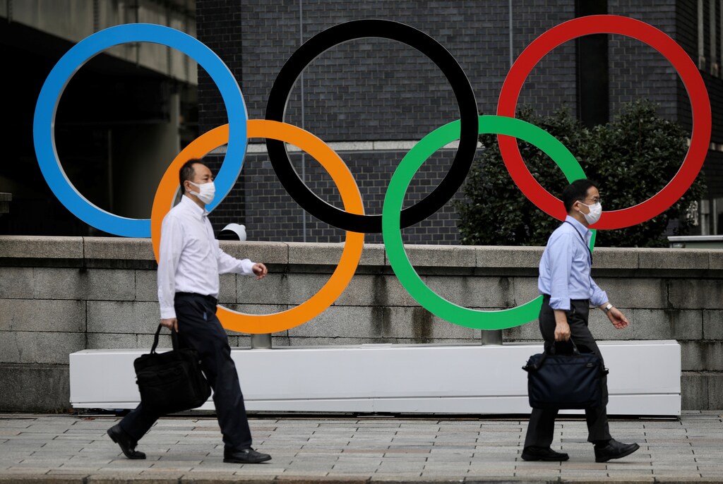 Men walk past the Olympic Rings in the commercial district of Nihonbashi during the Olympic games amid the coronavirus disease (COVID-19) outbreak in Tokyo, Japan August 4, 2021. REUTERS/Kevin Coombs - RC2ZXO9V3VL1