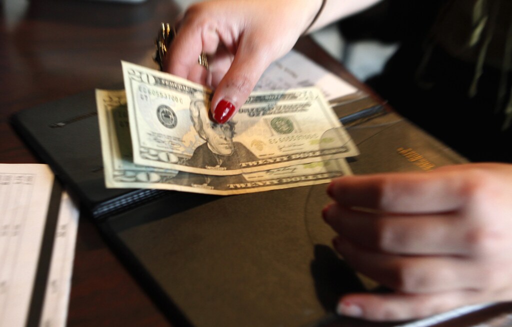 A customer pays her lunch bill at the Other Side Cafe in Boston, Massachusetts in this file photo taken on October 1, 2009. U.S. retailers gave investors an early Christmas present, posting their first monthly sales increase in more than a year and suggesting that wounded consumers might begin to heal in time for the crucial holiday season October 8, 2009. REUTERS/Jessica Rinaldi/Files (UNITED STATES BUSINESS POLITICS) - GM1E5A81SZP01