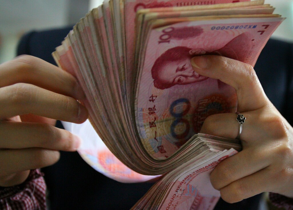 A Chinese bank employee counts yuan notes at a local bank in Nanjing, capital of east China's Jiangsu province, March 6, 2006. China's yuan is likely to appreciate around 3 percent a year in the near term, a prominent economist and adviser to parliament said on Sunday. REUTERS/Stringer - GM1DSCFNGIAA