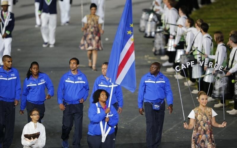 Cape Verde's flag bearer Adysangela Moniz holds the national flag as he leads the contingent in the athletes parade during the opening ceremony of the London 2012 Olympic Games at the Olympic Stadium July 27, 2012. REUTERS/Mike Blake (BRITAIN - Tags: OLYMPICS SPORT) - LM2E87R1PNAPT