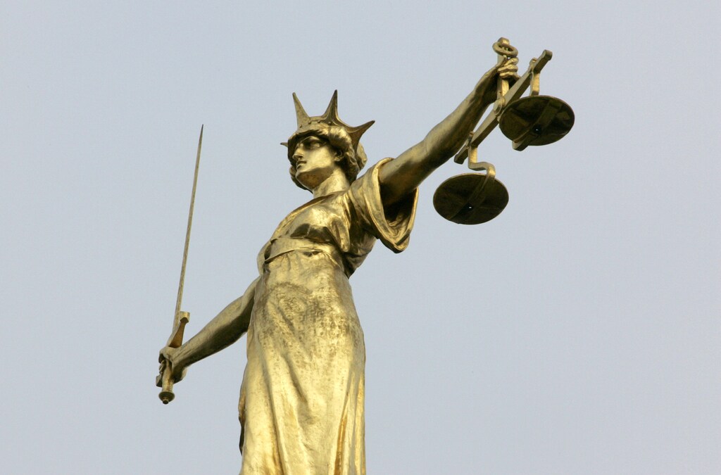 A statue representing the scales of justice is seen on the roof of the Old Bailey courts in central London, January 26, 2007. British Prime Minister Tony Blair's ruling Labour Party faced new embarrassment over law and order on Friday after a judge freed a convicted paedophile in part because the government had warned the prisons were full. REUTERS/Toby Melville (BRITAIN) - GM1DULXXYFAA