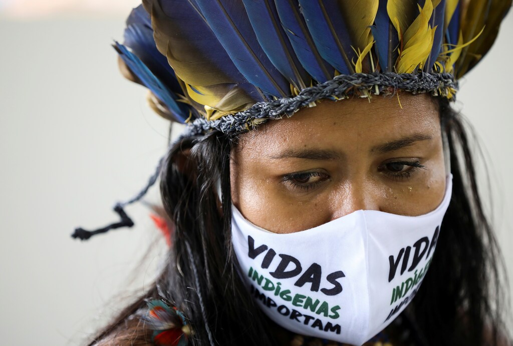 Una mujer indígena, con una máscara facial que dice "Las vidas de los indígenas importan", mira durante el funeral del Jefe Messias Kokama, de 53 años, del Parque das Tribos, que falleció debido a la enfermedad coronavirus (COVID-19), en el Parque das Tribos de Manaus, Brasil, el 14 de mayo de 2020.