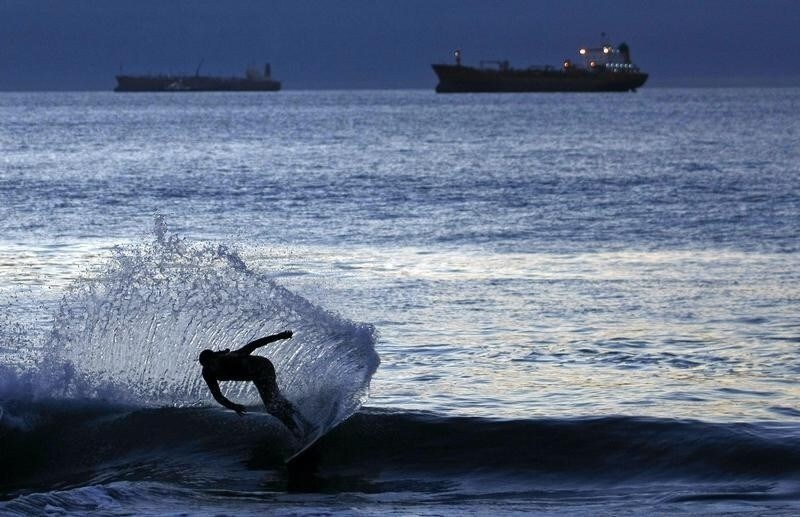 A surfer rides a wave during sunset in Vina del Mar city, about 75 miles (121 Km) northwest of Santiago, March 20, 2010. People slowly return the normal life in the coastal border after suffering an earthquake and tsunamis in much of southern Chile on February 27, 2010.