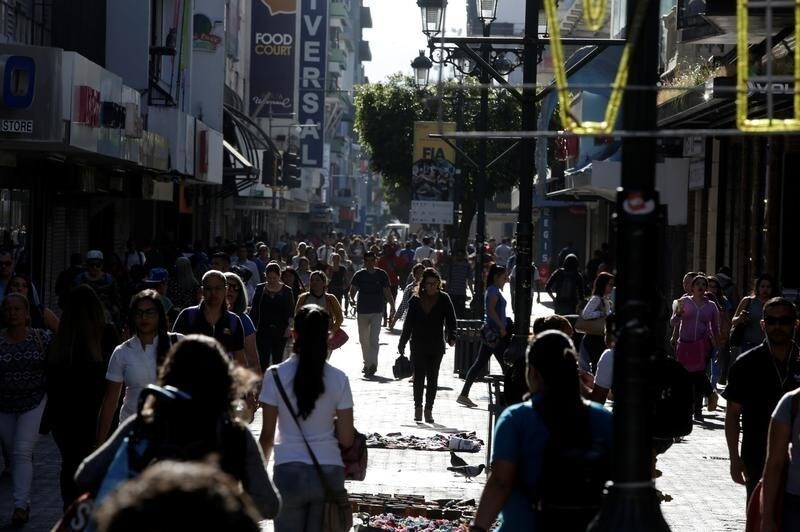 People walk down the central avenue, one day after Costa Ricans elected Carlos Alvarado Quesada as new president, in San Jose, Costa Rica April 2, 2018. REUTERS/Juan Carlos Ulate - RC160FE6DB00