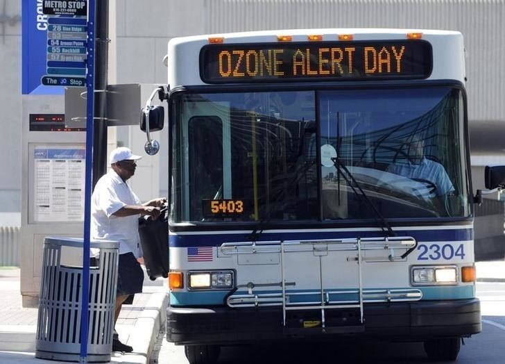 A passenger enters a Kansas City Metro bus that warns of an Ozone Alert in Kansas City, Missouri, August 1, 2011. Sticky heat was expected to smother much of the country's midsection in coming days as hotter-than-usual temperatures continued to roast parts of the Midwest and South, forecasters said. REUTERS/Dave Kaup (UNITED STATES - Tags: ENVIRONMENT)