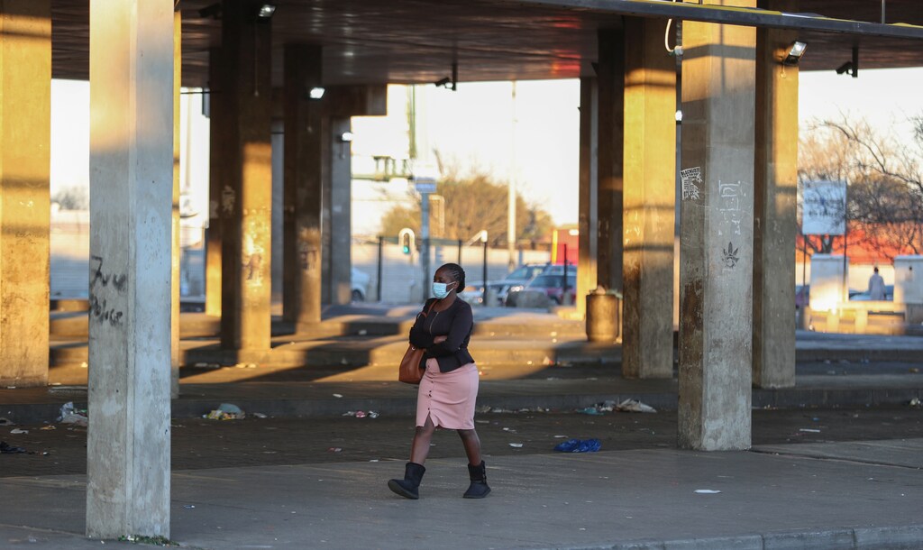 A Stranded commuter walks at a deserted Baragwanath taxi rank during a protest by the South African minibus taxi operators against the government's financial relief package to the taxi industry, during the coronavirus disease (COVID-19) lockdown, in Soweto, South Africa, June 22, 2020. REUTERS/Siphiwe Sibeko - RC2AEH9TH63Z