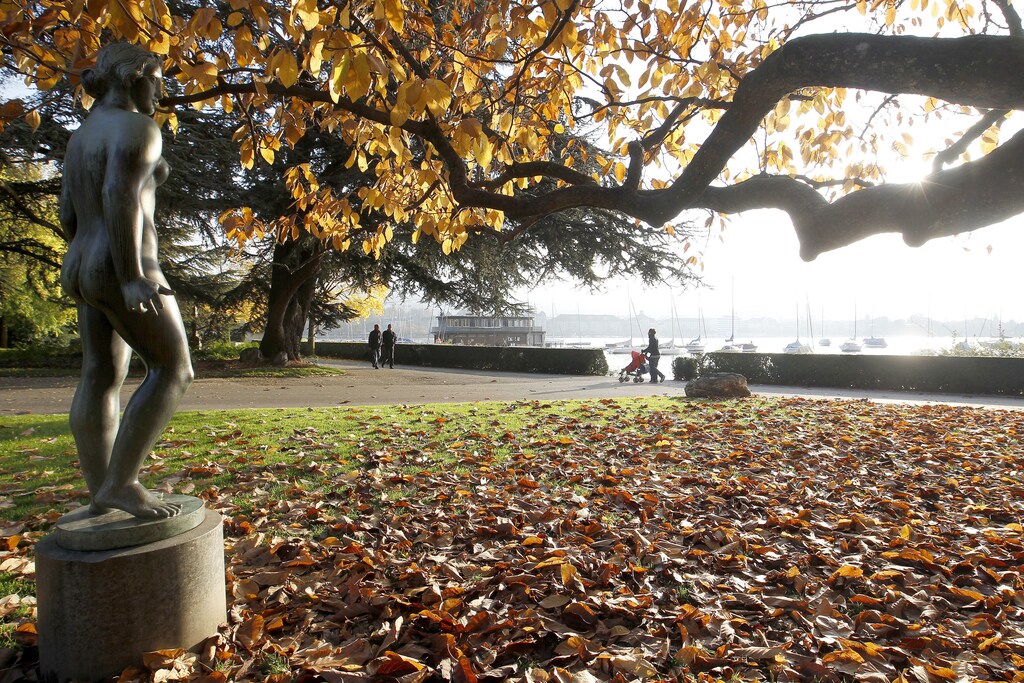 People walk past the statue 'Aphrodite' by late Danish sculptor Einar Utzon-Frank (1888-1955) during sunny autumn weather at a park on the borders of Lake Zurich in Zurich October 26, 2010. REUTERS/Arnd Wiegmann (SWITZERLAND - Tags: ENTERTAINMENT ENVIRONMENT) - RTXTUCA