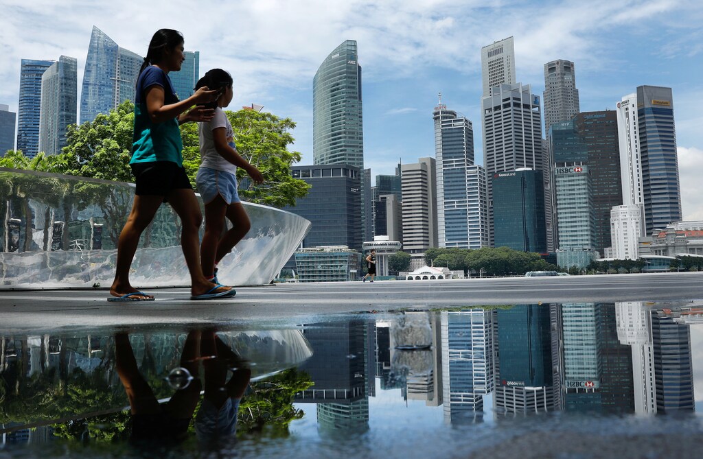People pass the skyline of Singapore October 11, 2017. REUTERS/Edgar Su - RC19D146ABD0