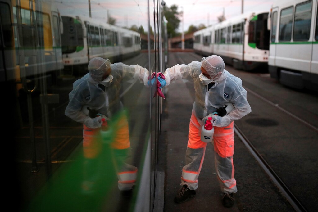 French employee Christophe, 50, wearing a protective suit and mask, disinfects a tramway as the spread of the coronavirus disease (COVID-19) continues, in Nantes, France, April 15, 2020. REUTERS/Stephane Mahe - RC285G9LIH59