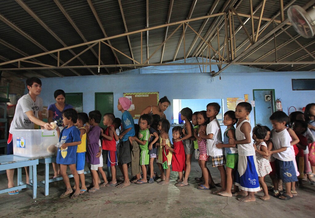 Children queue for a free meal in Manila, the Philippines.