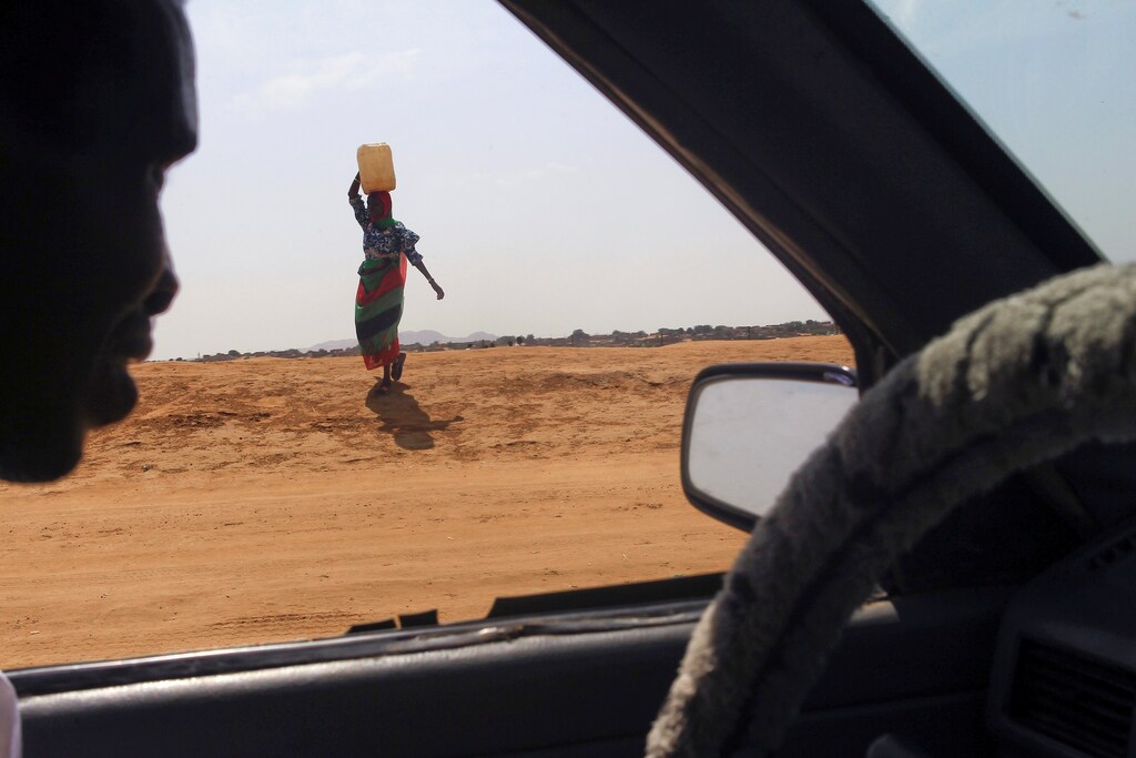 A woman carries water in Abu Shock IDPs camp in Al Fashir, capital of North Darfur, Sudan, September 6, 2016. REUTERS/Mohamed Nureldin Abdallah - RTX2OCMZ