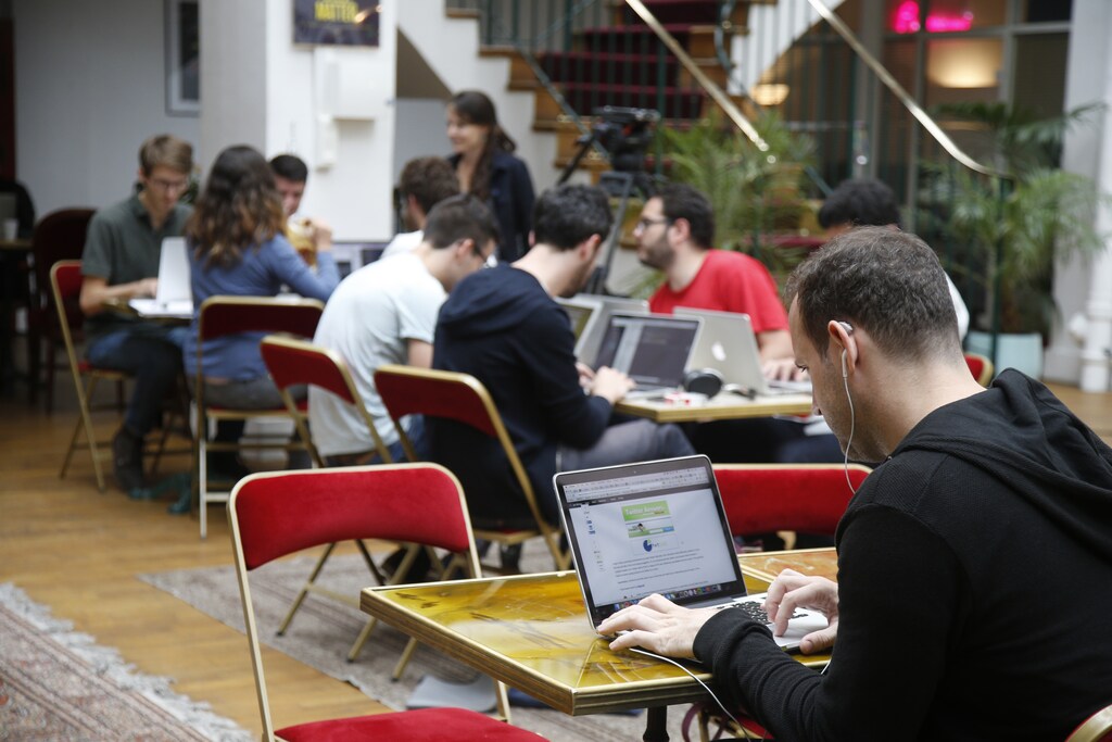 Entrepreneurs work at their computer laptops at the so-called "incubator" of French high-tech start-ups "TheFamily" in Paris, France, July 27, 2015.