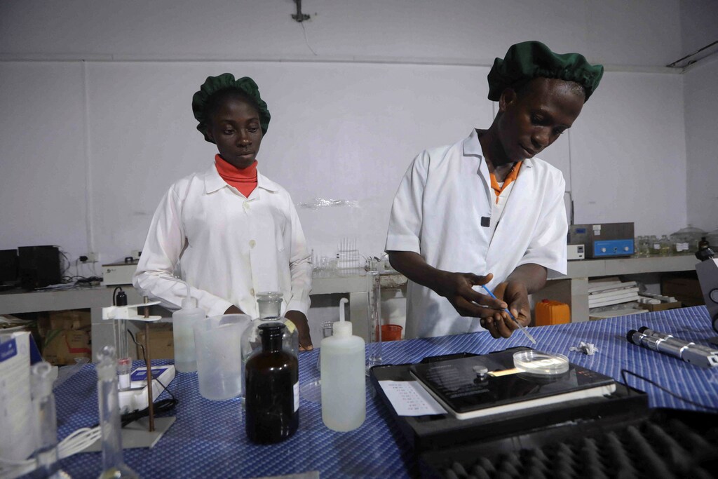 Nigerian laboratory workers perform an analysis.