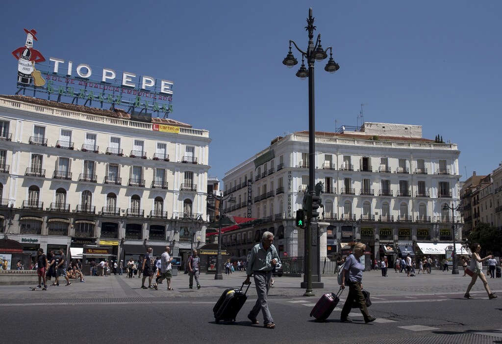 Tourist carry their belongings during a hot summer day at Madrid's landmark Plaza Mayor, Spain, June 26, 2015. Spain between January and May received a record high of 22.5 million foreign tourist visits, a 5.1 percent increase, according to Spain's Ministry of Industry, Energy and Tourism. REUTERS/Sergio Perez - RTX1HWZ7