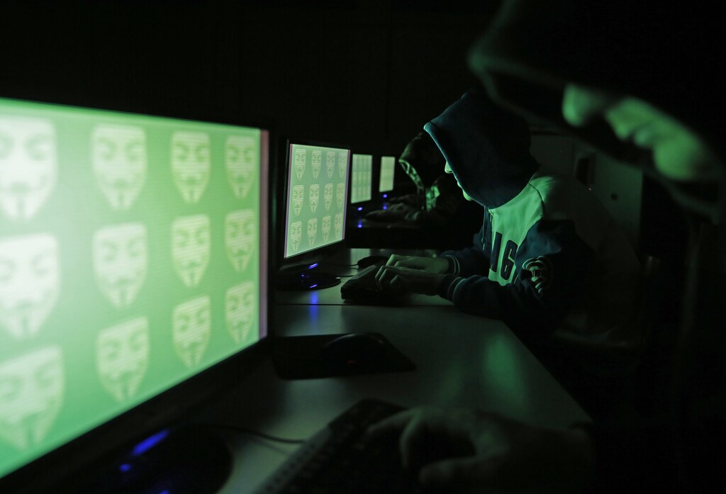 People pose in front of a display showing the word 'cyber' in binary code, in this picture illustration taken in Zenica December 27, 2014. A previously undisclosed hacking campaign against military targets in Israel and Europe is probably backed by a country that misused security-testing software to cover its tracks and enhance its capability, researchers said. Picture taken December 27, 2014. REUTERS/Dado Ruvic (BOSNIA AND HERZEGOVINA - Tags: SCIENCE TECHNOLOGY CRIME LAW) - RTR4JEYR