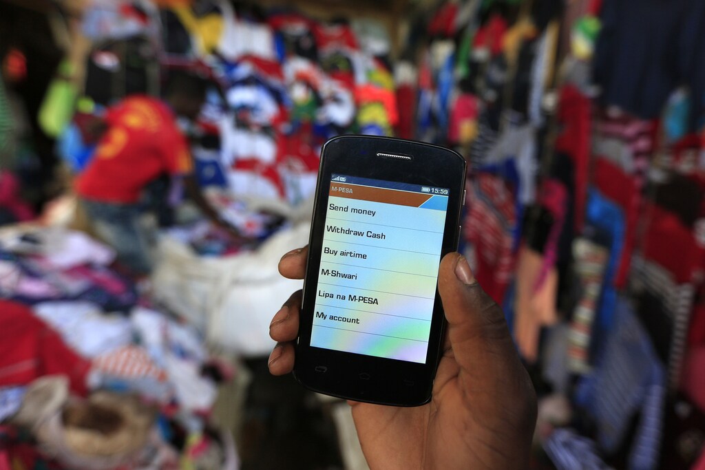 A man prepares to make an M-Pesa payment at an open-air market in Kibera, Nairobi.