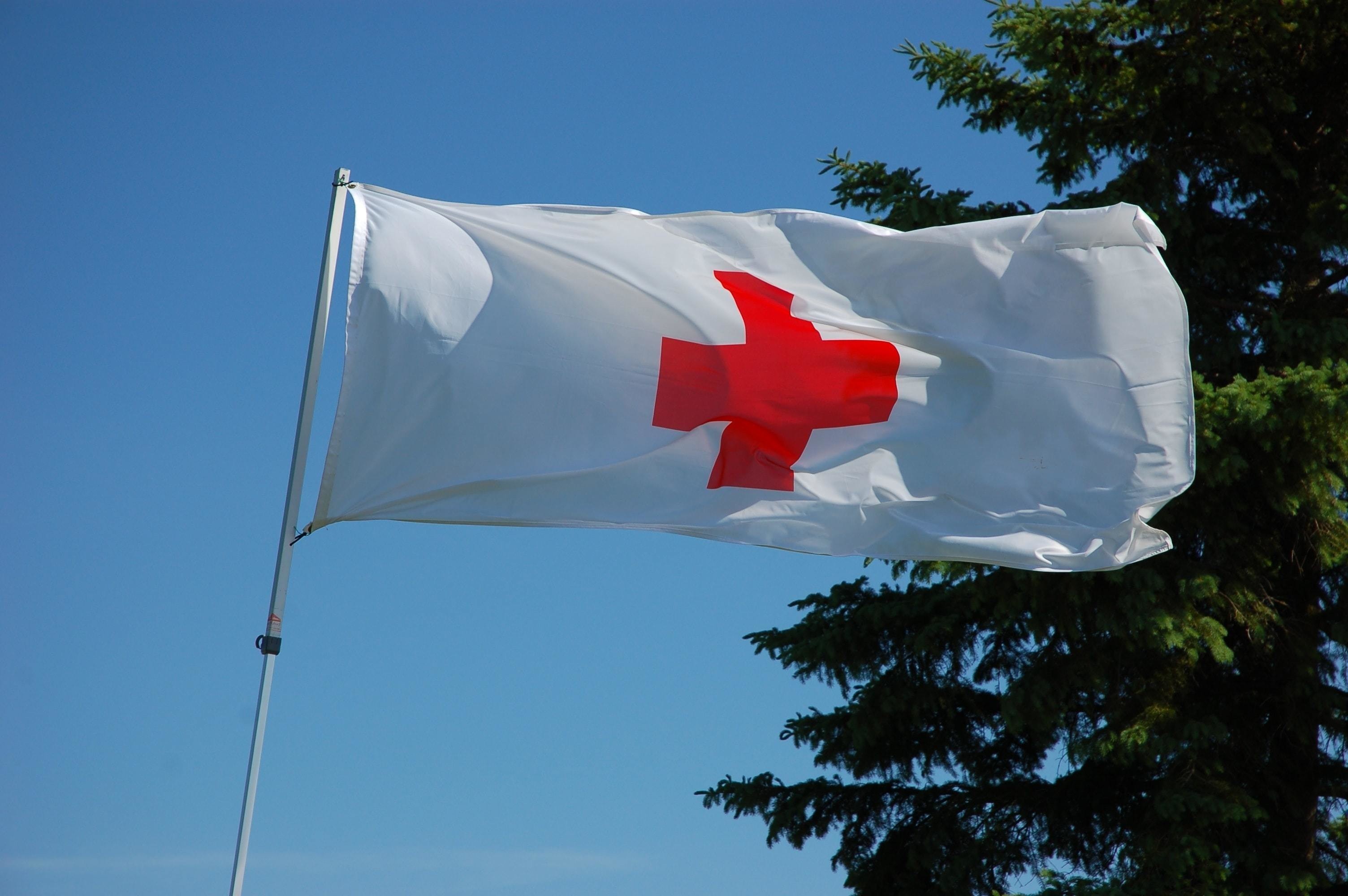 Humanitarian issues in 2022, Red Cross, flag, blue sky; humanitarian aid