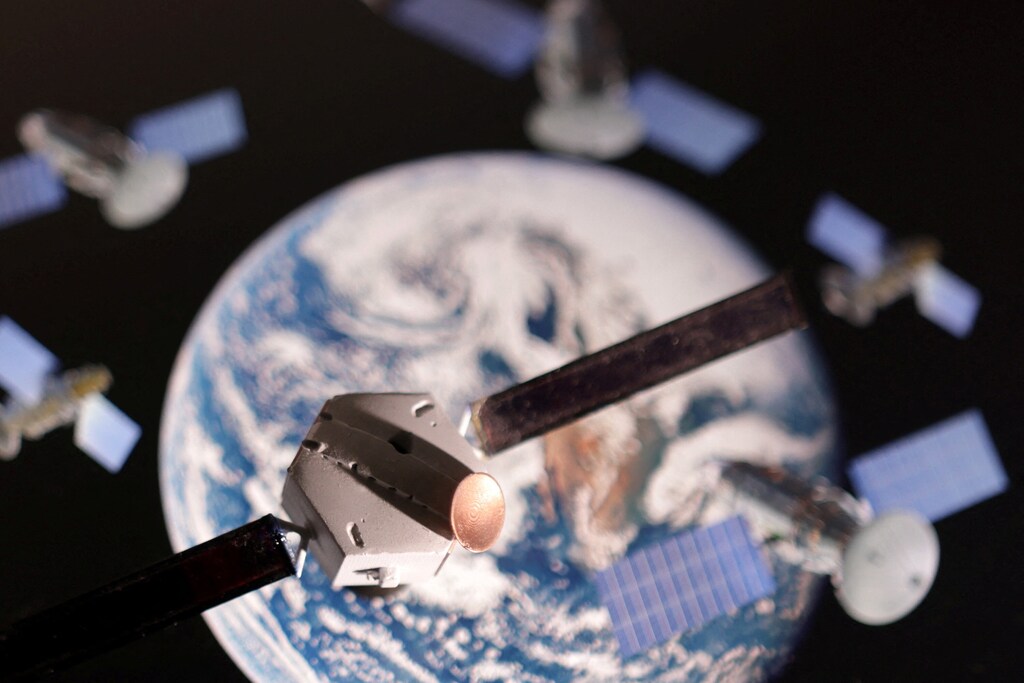 A satellite model is placed on a picture of Earth in this illustration taken November 25, 2024: Increased democratization in access makes building cyber resilience in space essential