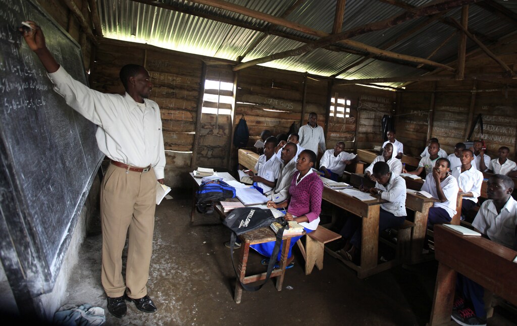 A teacher conducts a mathematics lesson to high school students in Democratic Republic of Congo town of Bunagana, an area under the control of M23 rebels fighting government forces in eastern Congo, near the border of Uganda October 19, 2012. REUTERS/James Akena (DEMOCRATIC REPUBLIC OF CONGO - Tags: EDUCATION CIVIL UNREST SOCIETY) - GM1E8AK02O101
