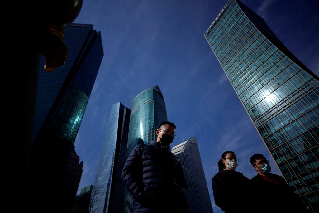 People wearing protective masks walk on a street, following new cases of the coronavirus disease (COVID-19), in Shanghai, China January 14, 2022. REUTERS/Aly Song