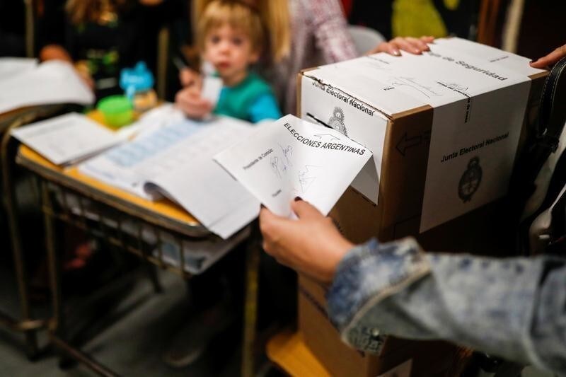 A child looks as a woman casts her vote at a polling station, in Buenos Aires, Argentina October 27, 2019. REUTERS/Carlos Garcia Rawlins - RC1948E95740