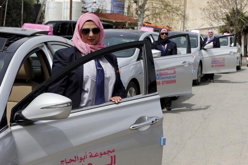 Female taxi drivers pose for a photo in front of their vehicles at Noor Jordan for Transport  Taxi Moumayaz's (Special Taxi) parking lot in Amman, Jordan, March 24, 2016. The Jordanian taxi company has launched a new service run only for women, exclusively by women. These three female drivers are among 10 women taxi drivers who will be working as taxi drivers for the first time in Jordan, picking up only female passengers and families. The company chairman Abu al-Haj said they plan to hire another 10 women as drivers, and possibly more if the service expands.