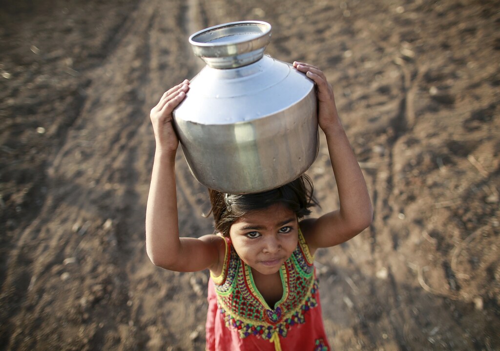Child carrying water India drought.