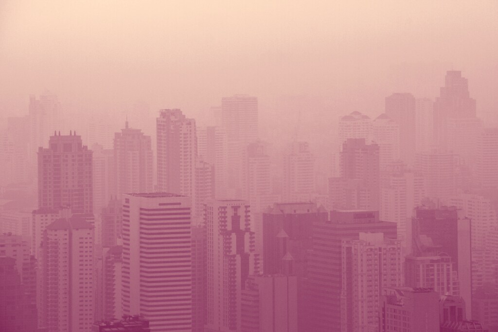 Un paisaje urbano de rascacielos envuelto en una espesa niebla de smog: Las herramientas de IA permiten obtener información personalizada sobre la exposición a la contaminación.
