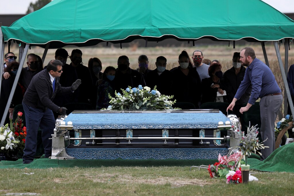 Family members of JBS USA meat packing plant employee Saul Sanchez watch as his casket is lowered during his funeral after he died of coronavirus disease (COVID-19) in Greeley, Colorado, U.S., April 15, 2020. REUTERS/Jim Urquhart - RC2C5G9UP3JL