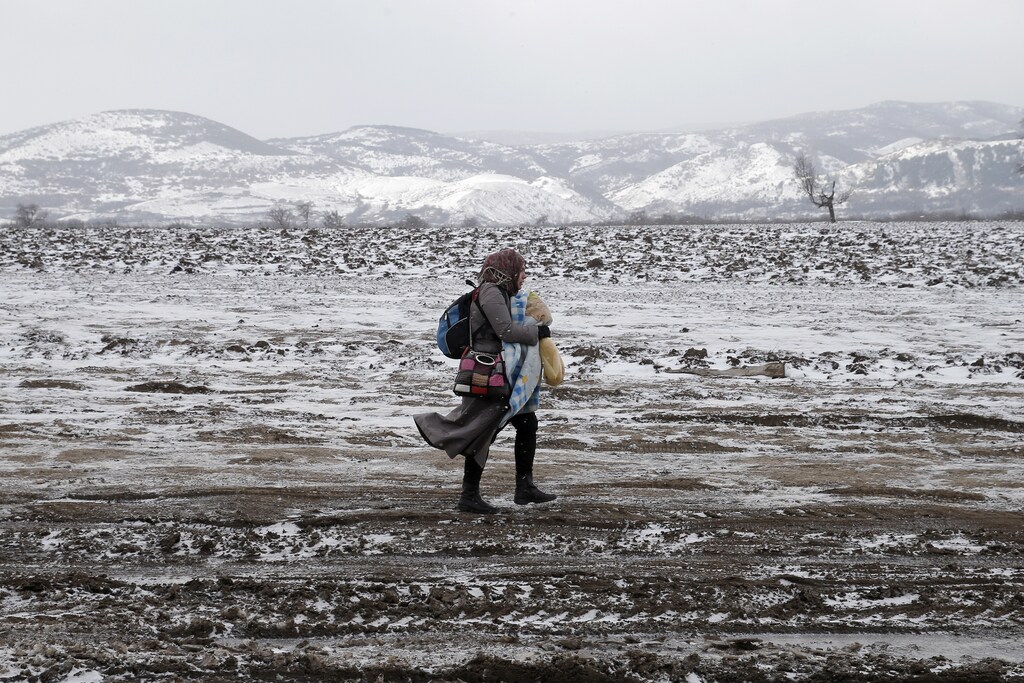A migrant walks through a frozen field after crossing the border from Macedonia, near the village of Miratovac, Serbia, January 18, 2016.