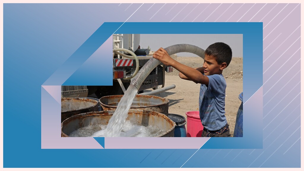 A boy fills a water tank from a truck during the water crisis outside his family home which sits on the bank of a former canal which has dried up in Iraq, October 20, 2022.