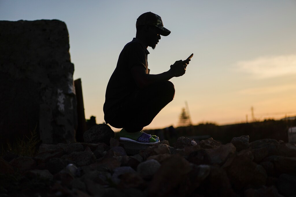 Ali, a migrant from Mali, looks at his phone outside a substandard housing in San Isidro, during the coronavirus disease (COVID-19) outbreak in Nijar, in the southern Spanish region of Almeria, Spain, April 29, 2020. Picture taken April 29, 2020. REUTERS/Juan Medina - RC21FG9PXDQP