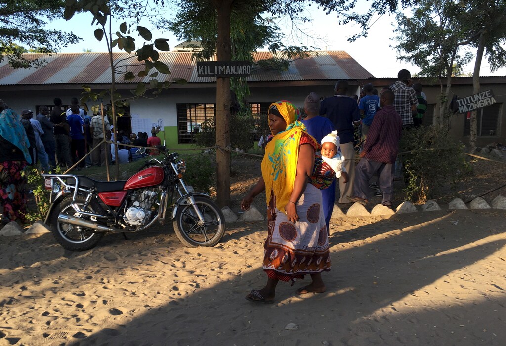 A woman carries her child as she arrives at a polling station before the opening of the voting process during the presidential and parliamentary election in Temeke district of Dar es Salaam, October 25, 2015. Tanzanians voted on Sunday in presidential and parliamentary polls in which the ruling party is expected to fend off rivals led by former Prime Minister Edward Lowassa, who has tapped into mounting anger over corruption and the slow pace of change. REUTERS/Drazen Jorgic - GF20000031743