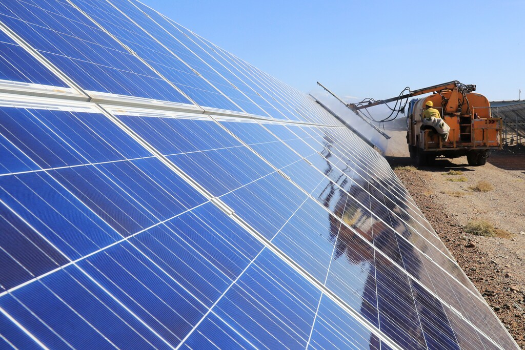 A worker operates a machinery to clean solar panels at a photovoltaic industrial park in Hami, Xinjiang Uighur Autonomous Region, China October 22, 2018. Picture taken October 22, 2018. REUTERS/Stringer ATTENTION EDITORS - THIS IMAGE WAS PROVIDED BY A THIRD PARTY. CHINA OUT. - RC1863B9EEF0