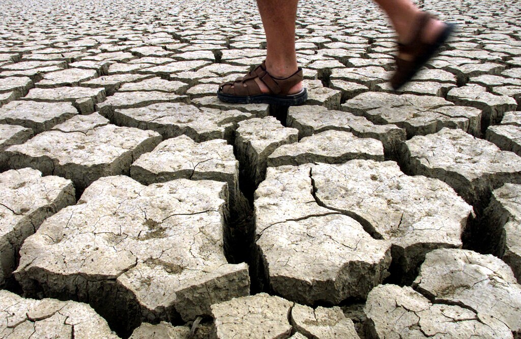 A man walks in the dried-out lake of Jato near the Sicilian village of Partinico July 15, 2002. The Italian government prepared on Sunday to send in the army to help combat a drought that has withered crops, damaged industry and provoked fury in the southern half the country. With a state of emergency declared in four regions, ministers promised at the weekend to throw everything they had at the mounting problem which has been caused by a mix of unusually dry weather and poor water management. NO RIGHTS CLEARANCES OR PERMISSIONS ARE REQUIRED FOR THIS IMAGE NTRES REUTERS/Tony Gentile PC/CRB - RP3DRHXPBCAB