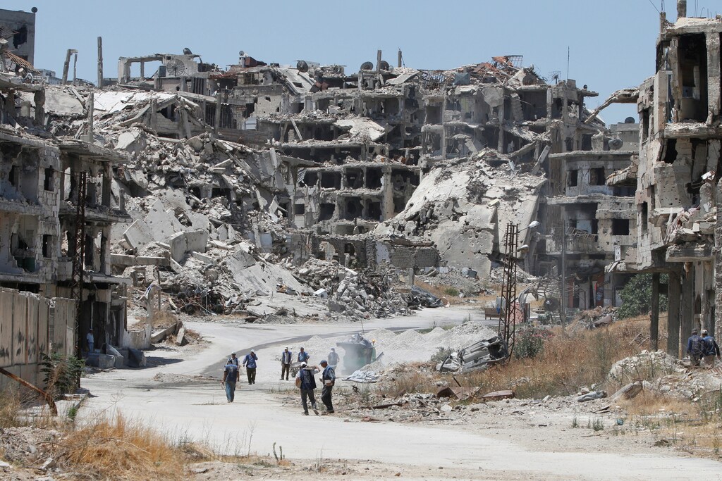 Workers collect the rubble of damaged buildings to be recycled and reused for reconstruction, under the supervision of the United Nations Development Programme (UNDP) in Homs, Syria.