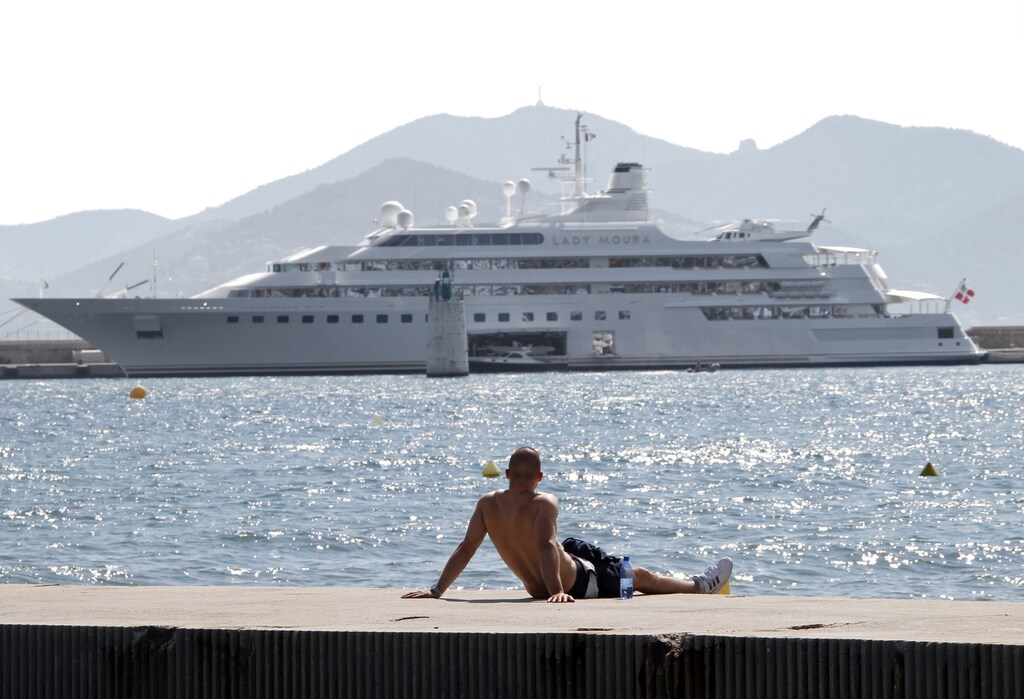 A man enjoys the sunny weather as he looks at the Lady Moura Yacht during the 63rd Cannes Film Festival May 17, 2010. REUTERS/Eric Gaillard (FRANCE - Tags: SOCIETY ENVIRONMENT) - GM1E65H1T2201