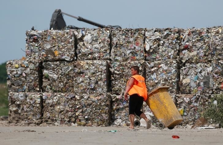 An employee walks past bundels of compressed recyclable materials at a solid waste treatment plant in the village of Nizhnerussky, in Stavropol region, Russia May 18, 2018. REUTERS/Eduard Korniyenko