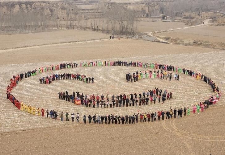 Villagers stand to form a smiling face in a field to celebrate the Chinese Lunar New Year, during a photo opportunity in Xiluoyin village of Yangqu county, Shanxi province February 12, 2011. The Lunar New Year began on February 3 and marks the start of the Year of the Rabbit, according to the Chinese zodiac. REUTERS/Stringer (CHINA - Tags: ANNIVERSARY SOCIETY) CHINA OUT. NO COMMERCIAL OR EDITORIAL SALES IN CHINA