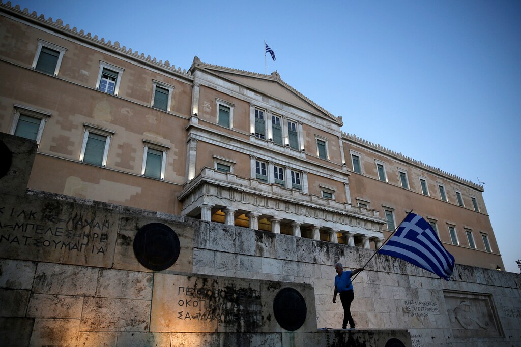 A man waves a Greek flag during an anti-goverment rally outside the Greek parliament building in Athens, Greece June 20, 2017.REUTERS/Costas Baltas - RTS17XA2