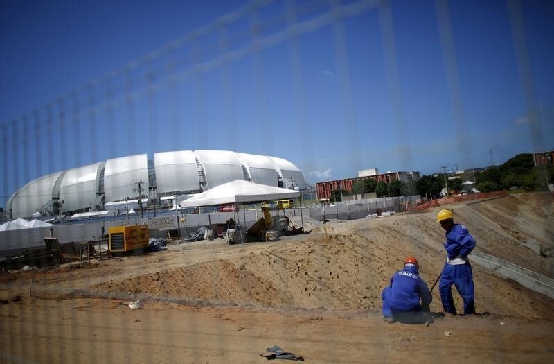 Laborers work at an unfinished infrastructure area outside of the Dunas arena soccer stadium in Natal, June 10, 2014. Natal will host its first of four scheduled matches of the 2014 World Cup on June 13.