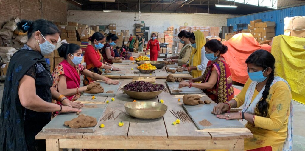 image of workers making incense sticks using powder from discarded flowers which were left outside temples