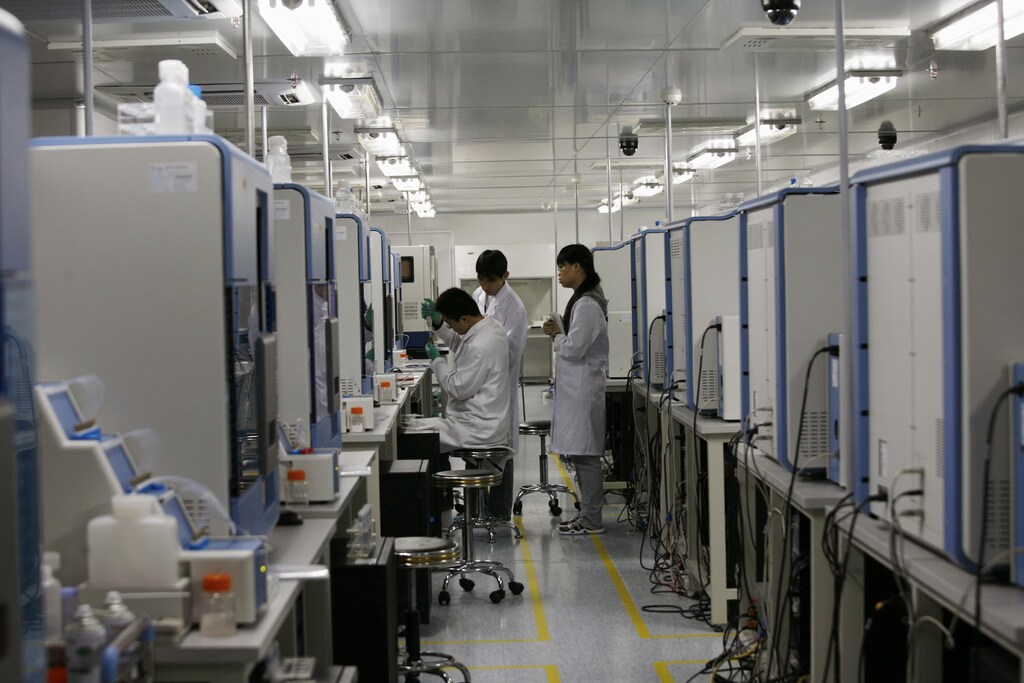 Three pharma workers are seen working in a lab in China.
