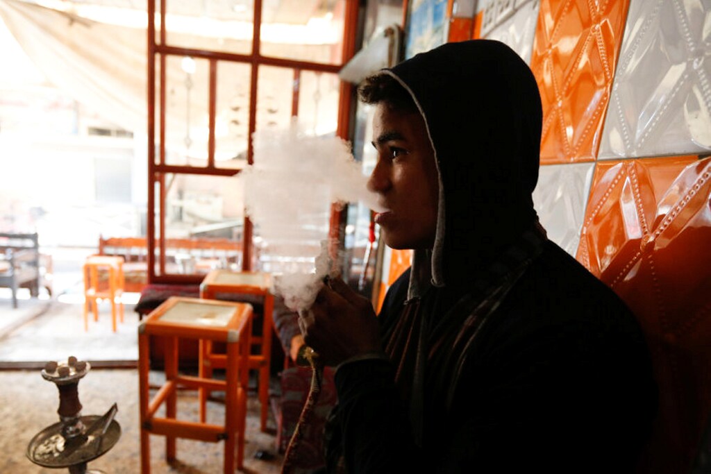 An Iraqi man smokes waterpipe at a coffee shop in the street of Mosul, Iraq, February 3, 2017. REUTERS/Ahmed Saad - RTX2ZIT5