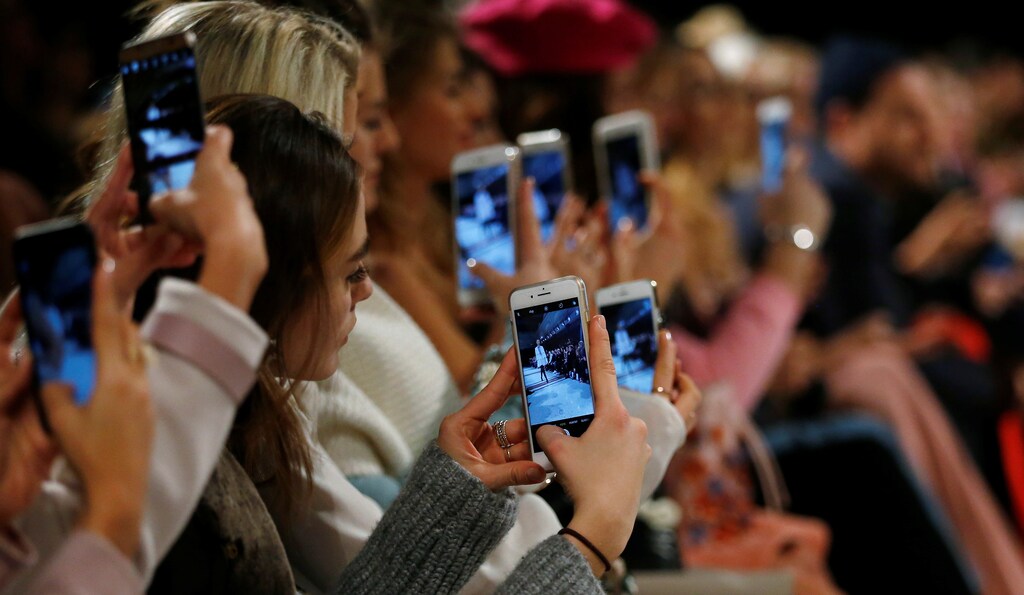 A so-called media influencer takes pictures as a model presents a creation by Marina Hoermanseder on the sidelines of the Berlin Fashion Week Autumn/Winter 2017/2018 in Berlin, Germany January 19, 2017. REUTERS/Hannibal Hanschke - RC1A9366F480