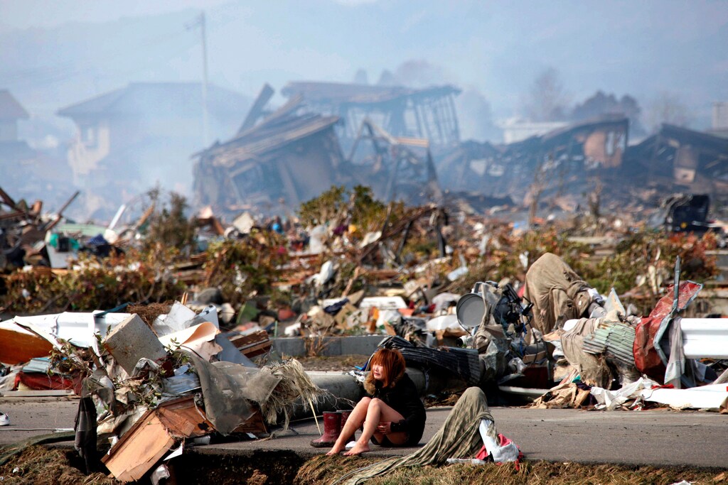 A woman cries while sitting on a road after an earthquake and tusnami destroyed the city of Natori, Miyagi Prefecture in northern Japan, March 13, 2011. Picture taken March 13, 2011. REUTERS/Asahi Shimbun/File Photo JAPAN OUT. NO COMMERCIAL OR EDITORIAL SALES IN JAPAN. FOR EDITORIAL USE ONLY. NOT FOR SALE FOR MARKETING OR ADVERTISING CAMPAIGNS. THIS IMAGE HAS BEEN SUPPLIED BY A THIRD PARTY. IT IS DISTRIBUTED, EXACTLY AS RECEIVED BY REUTERS, AS A SERVICE TO CLIENTS SEARCH "POY DECADE" FOR THIS STORY. SEARCH "REUTERS POY" FOR ALL BEST OF 2019 PACKAGES. TPX IMAGES OF THE DAY. - RC2SND9AMVDW